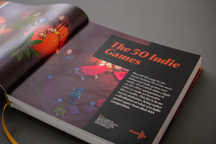 Open book displaying a page about 'The 50 Indie Games' with colorful graphics on a gray background.